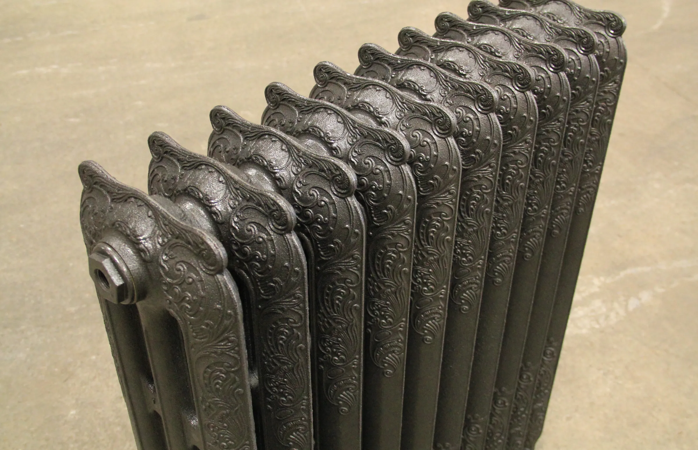 Détail des reliefs de fonte d’un radiateur orné dans l’atelier