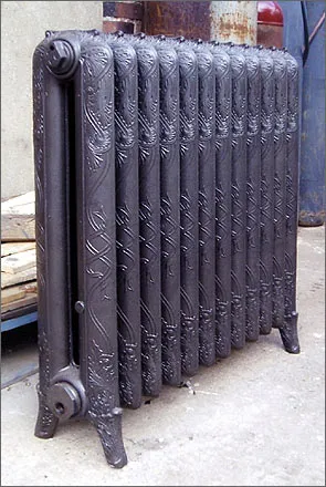 Radiateur National sombre installé devant un mur de briques