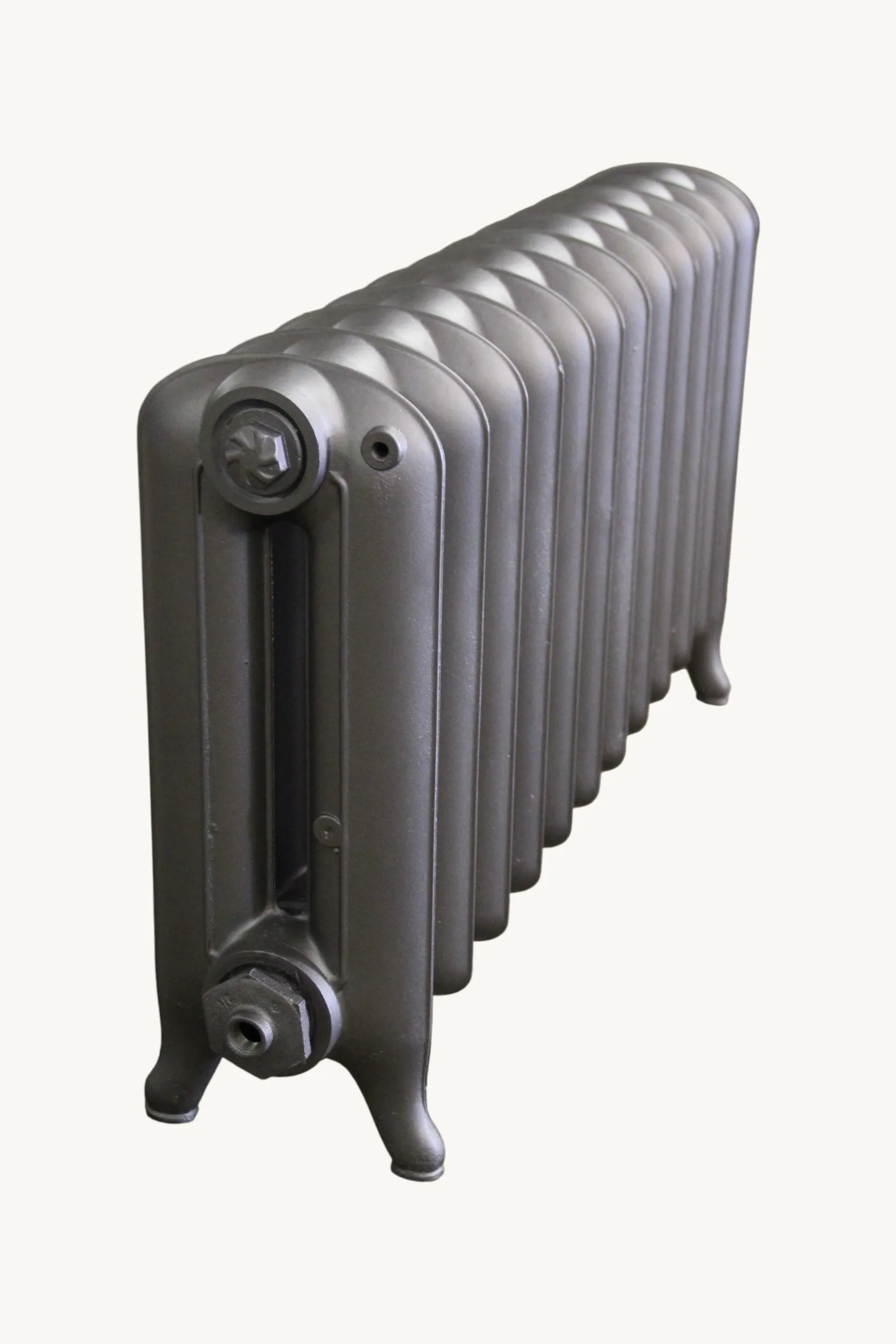 Radiateur en fonte lisse gris, vu de trois quarts avec ses pieds