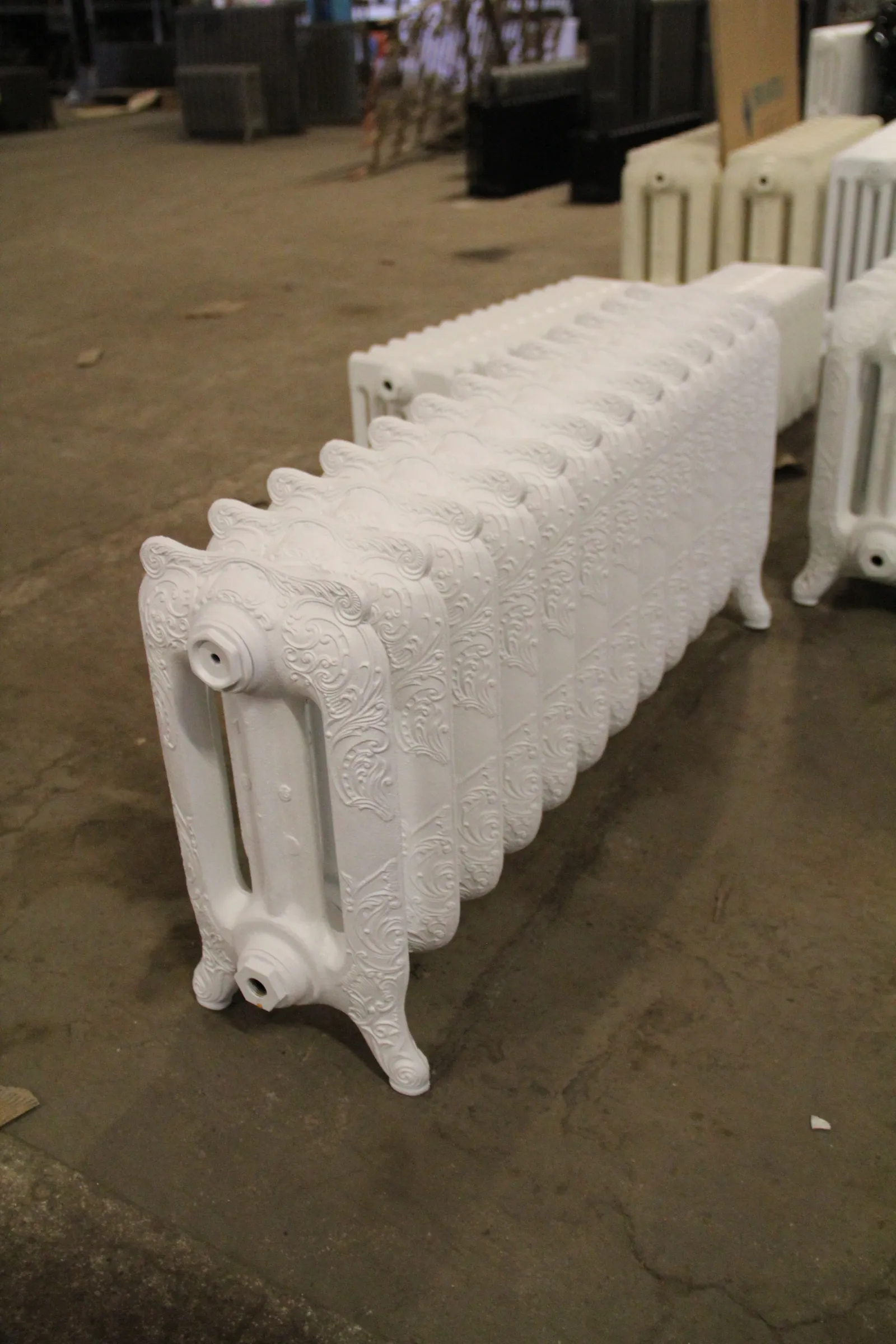 Radiateur Rococo blanc au premier plan dans l’atelier