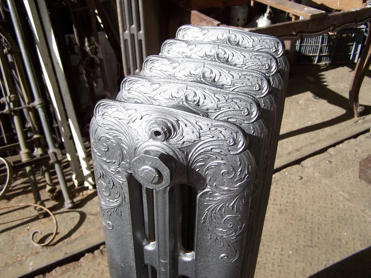 Radiateur Rococo en fonte grise vu depuis le dessus, avec rinceaux et feuillages en relief
